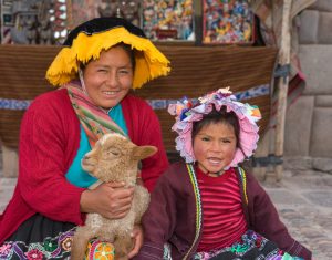 A mother and child pose for a photo for tourists in the Pisac square. (Kevin Kaiser | Travel Beat Magazine)