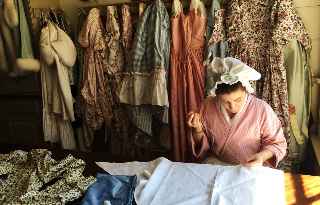 Learn all about the ladies' fashions of the Colonial period by stopping in to a working shop. This seamstress is working on a pattern by the light of the window. (Kevin Kaiser | Travel Beat Magazine)